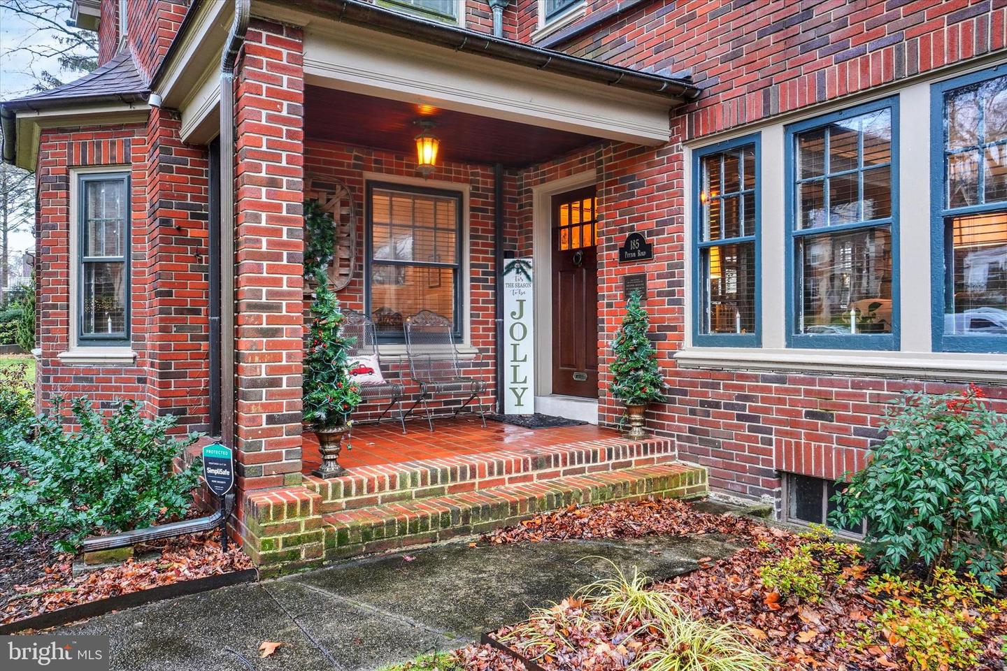 Covered front porch at 185 Peyton Road with original brick columns and Craftsman-style front door