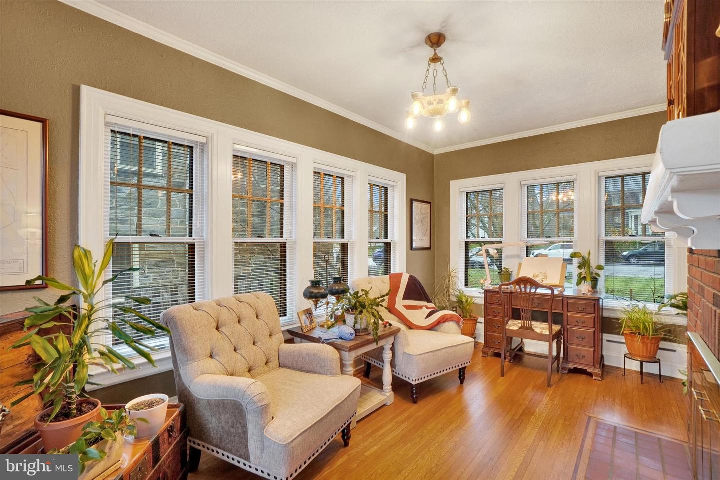 Sunroom at 185 Peyton Road with windows on three sides, original hardwood floors, and period light fixture