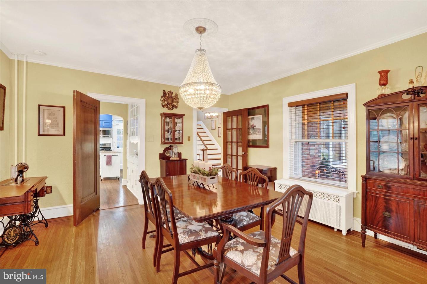 Dining room at 185 Peyton Road showing crystal chandelier, china cabinet, and view toward kitchen