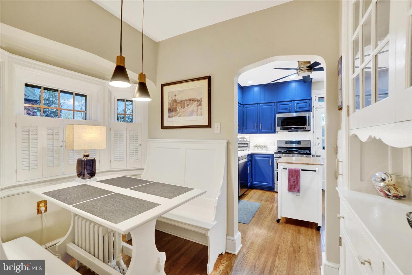 Breakfast nook at 185 Peyton Road with built-in bench seating, plantation shutters, and view into blue kitchen through arched doorway