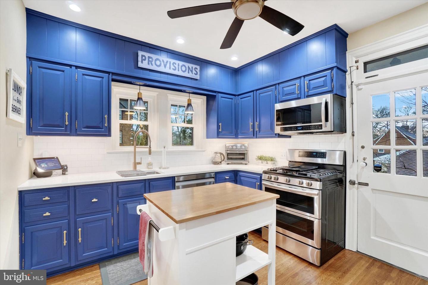 Updated kitchen at 185 Peyton Road with blue cabinets, white quartz countertops, butcher-block island, and stainless steel appliances