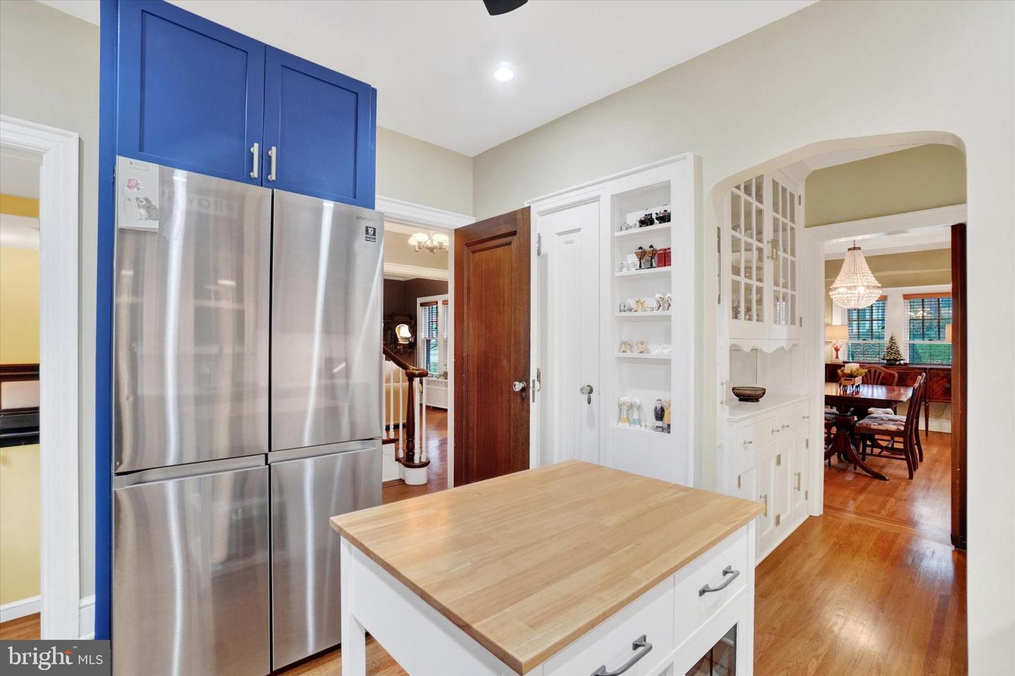 Kitchen at 185 Peyton Road showing butcher-block island, stainless refrigerator, original built-in cabinet, and arched doorway to dining room