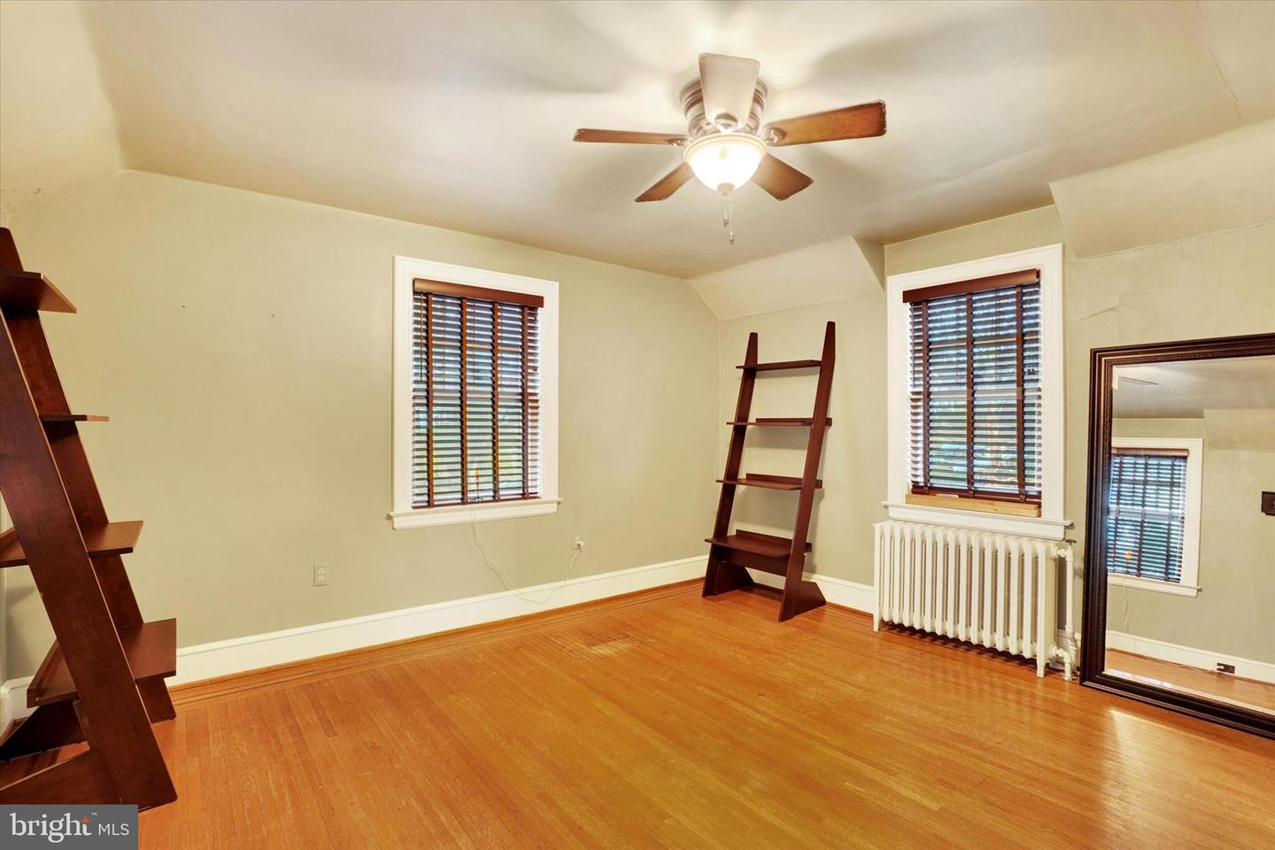 Second-floor bedroom at 185 Peyton Road with hardwood floors, ceiling fan, and original radiator