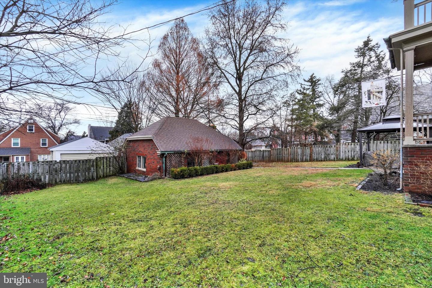 Backyard at 185 Peyton Road showing deep lot with mature trees and detached brick outbuilding