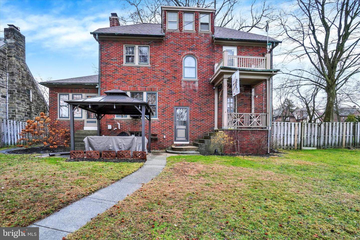 Rear of 185 Peyton Road showing arched stained glass window, back porch, and second-floor balcony